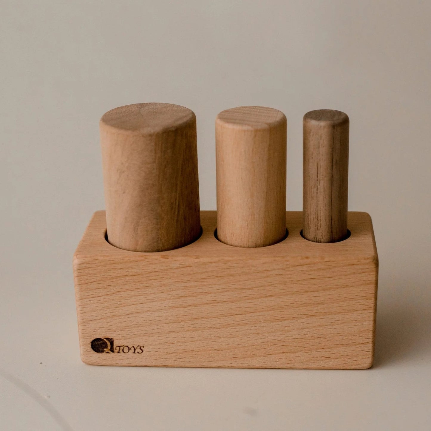 Wooden toy with cylindrical blocks on a plain background