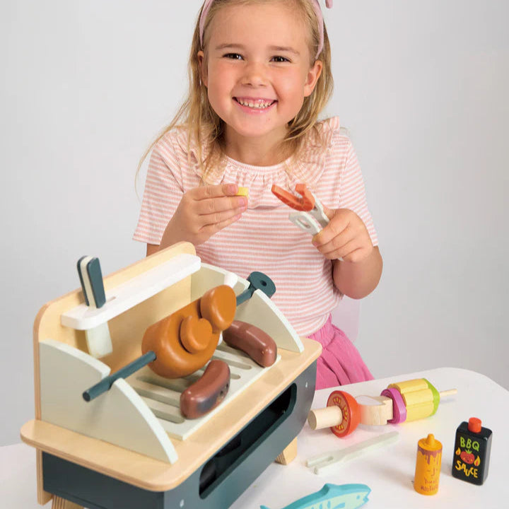 Young girl playing with a Barbeque Play Set by Tender Leaf Toys - Available from Curious Moonbeam NZ