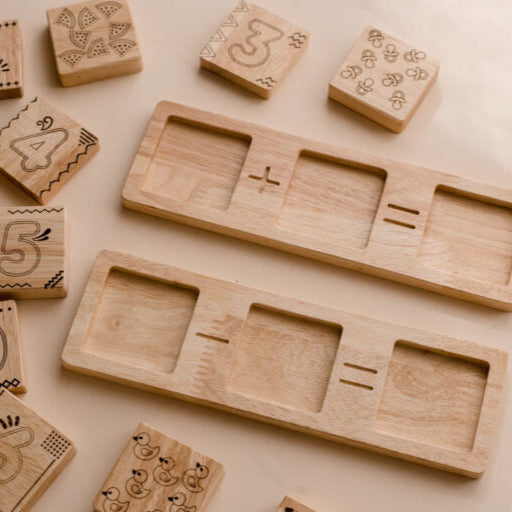 Wooden Two Piece Math Frame by QToys. educational blocks with numbers and mathematical symbols on a beige background