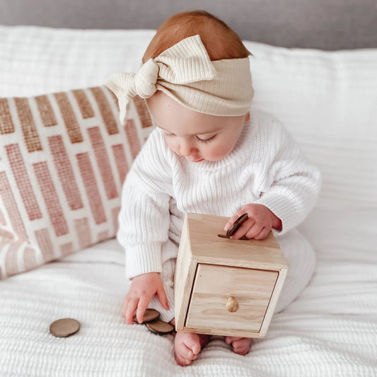 Baby playing with a wooden toy box 